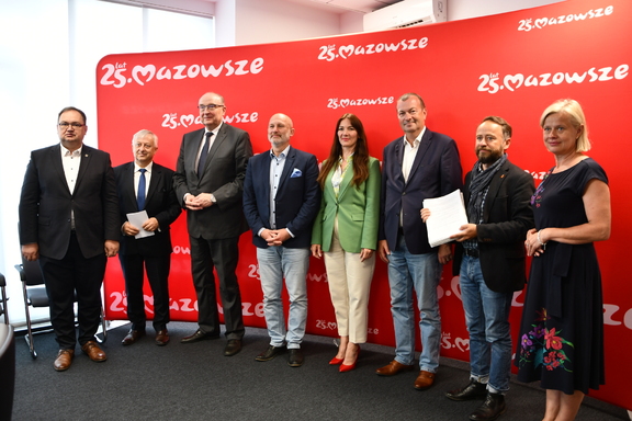 Przedstawiciele samorządu województwa mazowieckiego, Józefowa, Warszawy i Mazowieckiego Zarządu Dróg Wojewódzkich stoją na tle czerwonego baneru z napisem Mazowsze