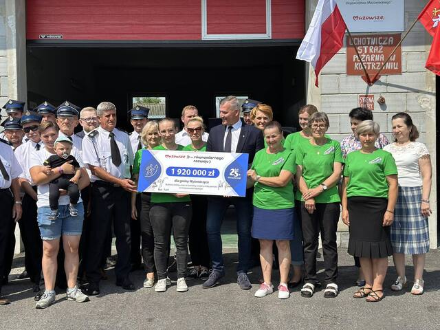 Wicemarszałek Rafał Rajkowski i beneficjenci z gminy Wyśmierzyce trzymają wspólnie duży czek