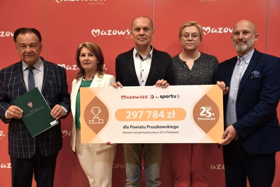 Beneficjenci z planszą informującą o dofinansowaniu