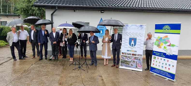 uczestnicy stoją przed ocieplonym budynkiem zakładu