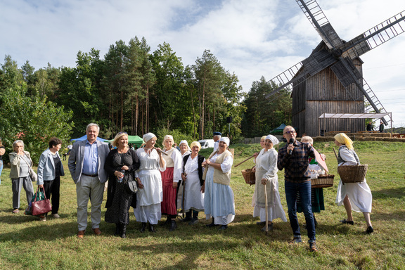 Uczestnicy festiwalu przed drewniany wiatrakiem