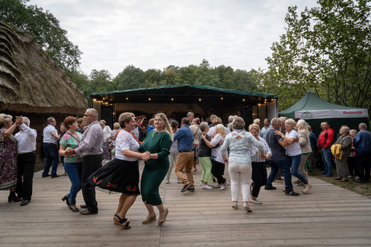 Uczestnicy festiwalu tańczą na parkiecie przed sceną