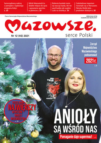 para wolontariuszy pozuje do zdjęcia przy choince