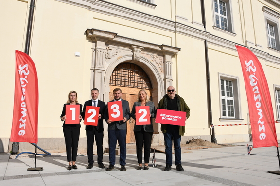 Radni województwa trzymają tabliczki z liczbą inwestycji