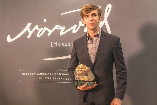 Laureat Patryk Walczak trzymający statuetkę konkursu 