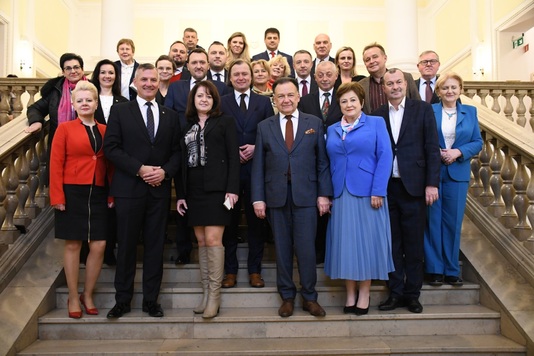 Pamiątkowe foto radnych i wojewody mazowieckiego – na schodach przed salą obrad sejmiku.