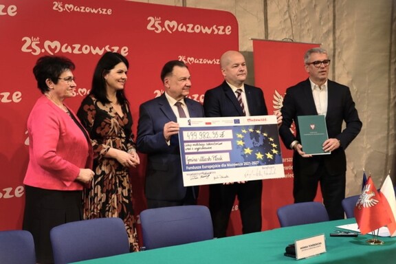 Władze z symbolicznym czekiem i kwotą