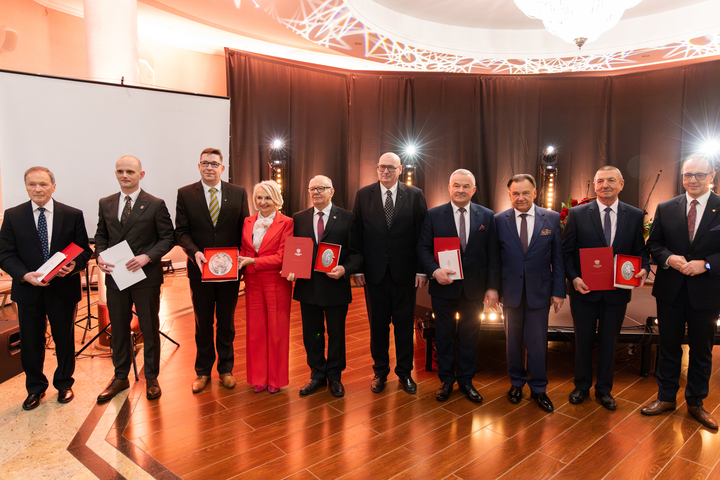 Marszałek Adam Struzik stoi na scenie wraz z wyróżnionymi medalami przez powiat płocki