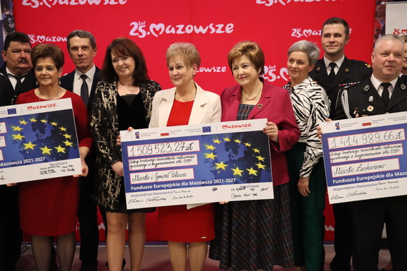 Beneficjenci z symbolicznymi czekami po przekazaniu wsparcia na inwestycje