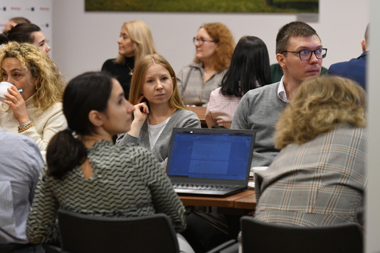 Uczestniczka konferencji przed otwartym laptopem