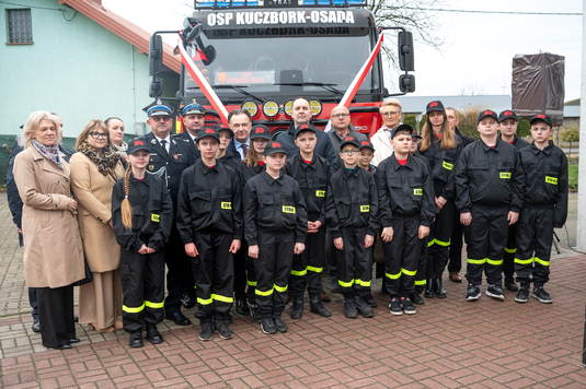 Zdjęcie grupowe na tle nowego wozu strażackiego