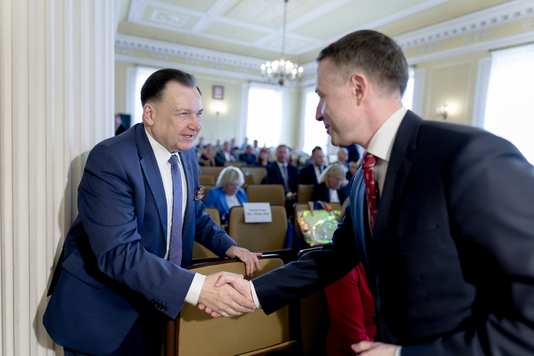 Gratulacyjny uścisk dłoni przewodniczącego sejmiku i marszałka.