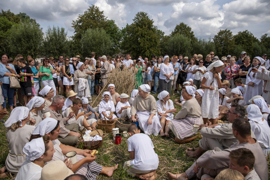 Rekonstruktorzy i zwiedzający w na łące 