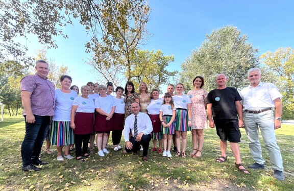 Grupa uśmiechniętych osób na łonie mazowieckiej natury.