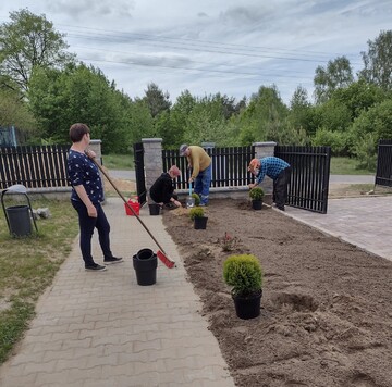 Zdjęcie przedstawia grupę osób sadzących rośliny ozdobne