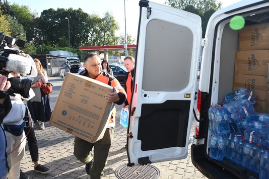 Karol Bielski ładuje dary dla powodzian do karetki.