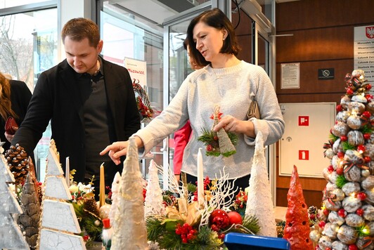 Pracownicy UMWM w Warszawie kupujący świąteczne ozdoby podczas kiermaszu.