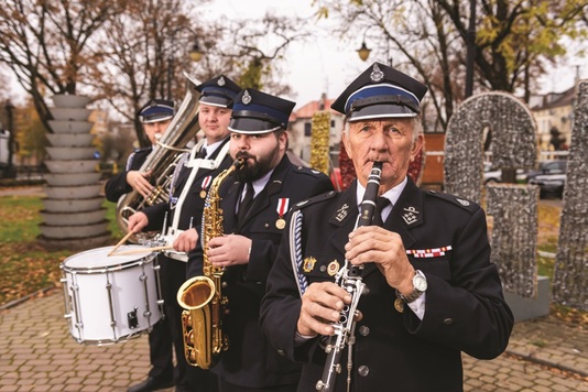 Członkowie orkiestry dętej Ochotniczej Straży Pożarnej w Głąbinie z instrumentami muzycznymi.