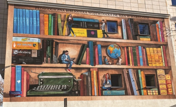 Mural na elewacji Pedagogicznej Biblioteki Wojewódzkiej im. KEN w Warszawie przedstawiający książki oraz gry edukacyjne ułożone na półkach uczniowskiego pokoju.